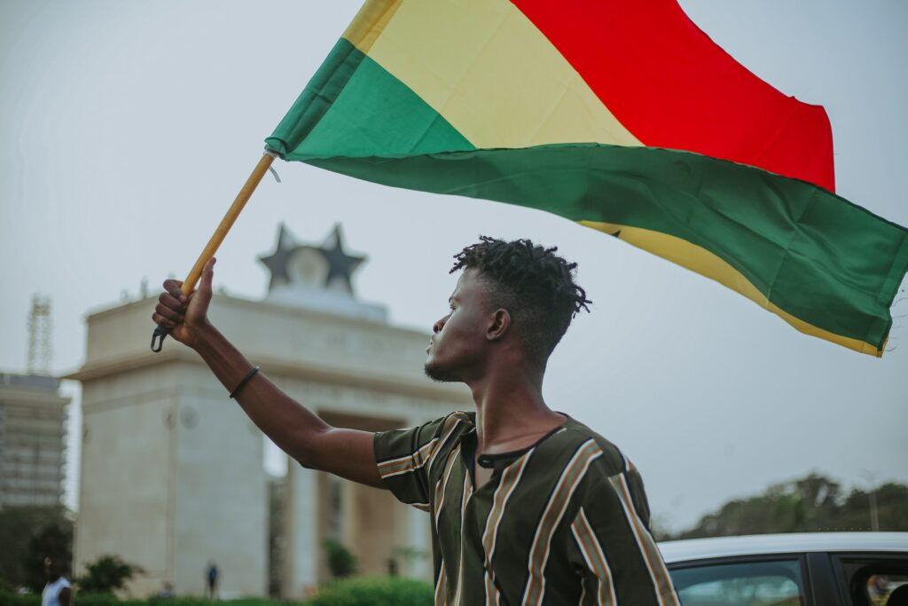Decorative image depicting a man holding the flag of Ghana.